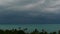 Dramatic gloomy sky with dark thunderstorm clouds over turquoise sea. Hurricane on ocean horizon. Vivid aerial timelapse