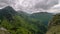 Dramatic grey clouds over green forest mountains landscape in spring nature Time lapse