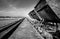 Dramatic high contrast black and white image of old rusty steel carts and rails on a salt processing plant.