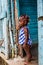 Dramatic image of small Haitian child standing in her doorway of their home looking for her mother.