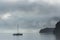 Dramatic landscape image looking across Derwentwater in Lake District towards Catbells snowcapped mountain with thick fog rolling