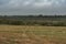 Dramatic landscape, late gloomy autumn, agricultural field after harvest with wild grass, cloudy weather