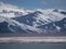 Dramatic landscape with snowy mountaintop in low cloudy sky. White snow on black rocks in low clouds. Awesome view to snow