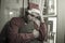 Dramatic lifestyle portrait of sad and depressed man in Santa Claus hat feeling lonely home alone by Christmas holiday thoughtful