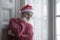 Dramatic lifestyle portrait of sad and depressed man in Santa Claus hat feeling lonely home alone by Christmas holiday thoughtful