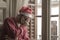 Dramatic lifestyle portrait of sad and depressed man in Santa Claus hat feeling lonely home alone by Christmas holiday thoughtful