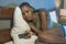 Dramatic lifestyle portrait of young sad and depressed black African American woman crying in bed holding mobile phone victim of