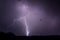 Dramatic lighting bolt falling during the night in Romania over rural area