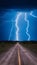 Dramatic lightning storm illuminating dirt road, atmospheric intensity