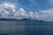 Dramatic looking clouds over sea. Billowing clouds hang over the ocean. Beautiful summer blue sky and white clouds over calm sea.