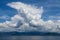 Dramatic looking clouds over sea. Billowing clouds hang over the ocean. Beautiful summer blue sky and white clouds over calm sea.