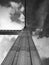 Dramatic monochrome perspective view of the support of a tall old steel suspension bridge with rows of riveted metal plates