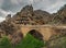 Dramatic mountain scenery with old stone bridge in dark rainy day