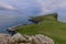 The dramatic Neist Point Cliff on the Isle of Isle of Skye overlooks the ocean, under a soft, pastel-hued sky