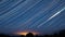 Dramatic Night Sky With Glowing Stars Trails And Meteoric Tracks Trails Rotate Above Countryside Rural Landscape. 4k