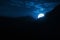 Dramatic Nighttime Moonrise Over Mountain Ridge and Pine Trees