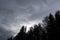 Dramatic northern scandinavian cloudy sky. Cold northern europe. Nature dark forest silhouette