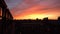 A dramatic orange and red sunset over the iconic roofs of Central London