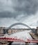 Dramatic panorama of the Newcastle upon Tyne North East Quayside swing bridge with thunder clouds and birds flying