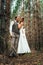 Dramatic picture bride and groom on the background of leaves forest backlight