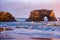 Dramatic pink sunset over Natural Bridges State Beach in Santa Cruz, California, USA. Amazing landscape with natural stone rock