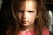 Dramatic portrait of beautiful sad little child girl with shadow on face. lonely in dark. Childhood and problems of parents and