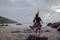 Dramatic portrait of long haired lady in floral formal dress on a stormy beach