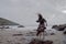 Dramatic portrait of long haired lady in floral formal dress on a stormy beach