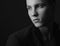 Dramatic portrait of a man theme: man sitting in a black suit with a pensive look on a dark background in the studio