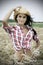 Dramatic portrait of pretty cowgirl in wheat field