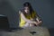 Dramatic portrait scared and stressed Asian Korean teen girl or young woman with laptop computer and mobile phone suffering cyber