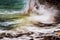 Dramatic powerful squirting water over coast rocks