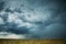 Dramatic Rainy Sky With Rain Clouds On Horizon Above Rural Landscape Field. Agricultural And Weather Forecast Concept