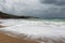 Dramatic rainy sky and stormy waves on a sand beach of the Aegean Sea in Rhodes