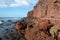 Dramatic red colored cliffs on the coast of Montana Roja mountain near El Medano, Tenerife, Canary Islands, Spain,