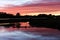 Dramatic red sunset on the river. Dark mystical photo.