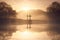 Dramatic religious photo illustration of Easter Sunday Morning reflecting a prayerful moment as a warm sun rises over a foggy lake