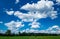 Dramatic Scenic Clouds in an Intense Blue Sky over Green Landscape Background