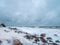 Dramatic seascape with a raging White sea and a fishing hut on the shore. Kandalaksha bay. Umba. Russia