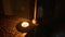 Dramatic setting of a closeup shot of a candle on a step with a single baluster in the background