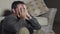 Dramatic shot of attractive sad and depressed man sitting on living room floor feeling desperate and stressed suffering depression