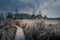 Dramatic shot of a boardwalk in a grassy field under the cloudy sky