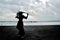 Dramatic silhouette of a long haired lady in floral formal dress on a stormy beach