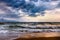 Dramatic sky on morning seascape. Storm on a sandy sea beach.