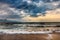 Dramatic sky on morning seascape. Storm on a sandy sea beach.