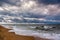 Dramatic sky on a morning seascape. Sunrise on a sandy beach.