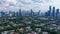 Dramatic sky over Jakarta downtown skyline where modern skyscrapers contrasts with poor residential district in