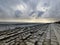 Dramatic sky over the pier at low tide in the evening