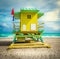 Dramatic sky over a South Beach yellow and green lifeguard hut