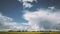 Dramatic Sky With Rain Clouds On Horizon Above Rural Landscape Camola Colza Rapeseed Field. Country Road. Agricultural